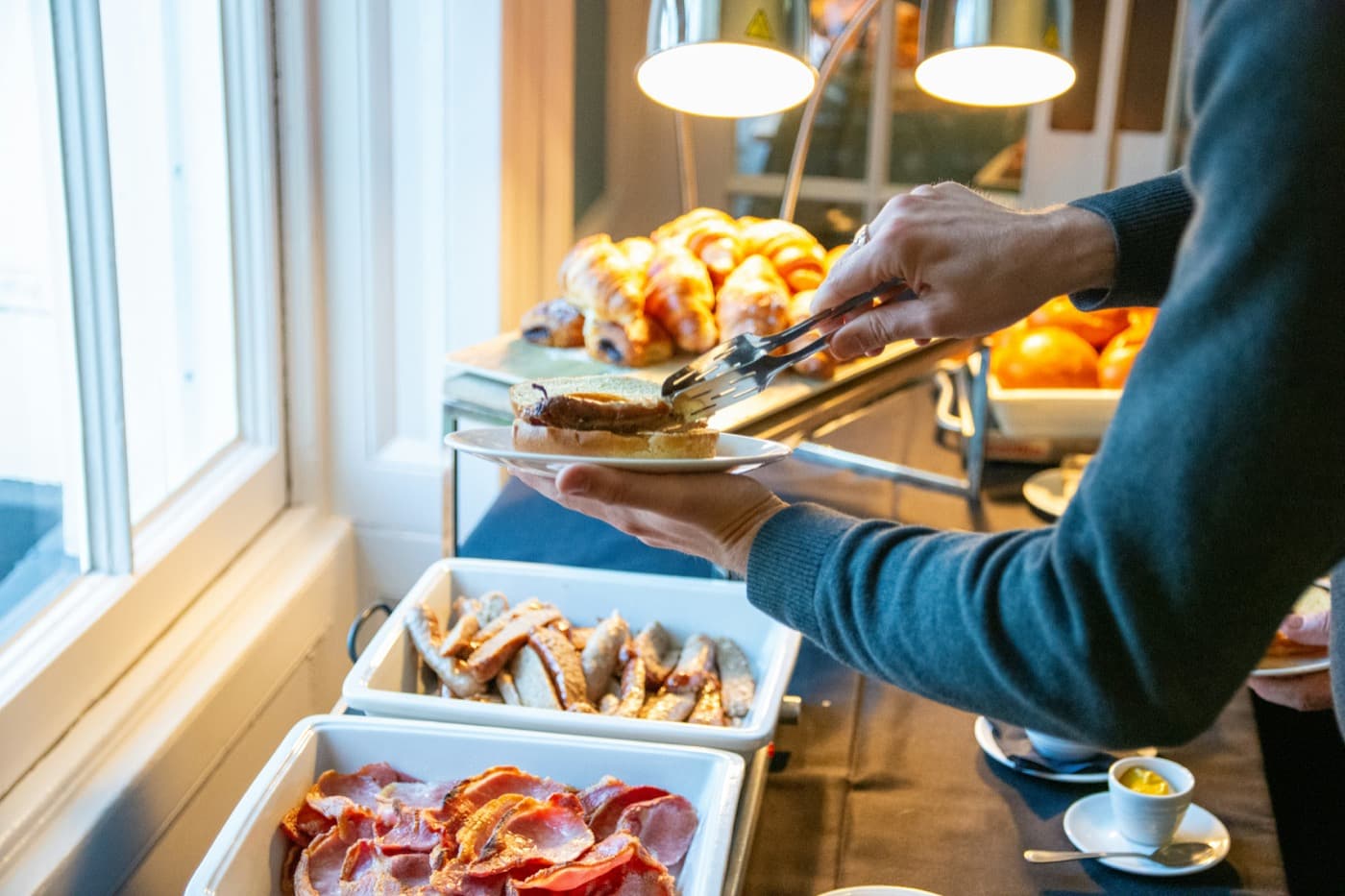 A staff member serving food from a buffet at a hospitality event